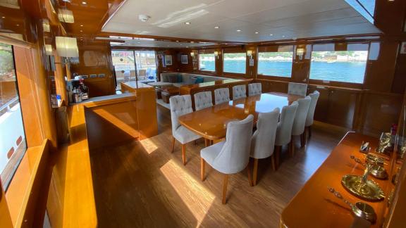 Spacious salon with dining table and seating area on yacht Gül Maria